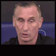 a close up of a man 's face with a black shirt on