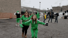 a group of people are dancing in a parking lot with a sign that says ' irish ' on it