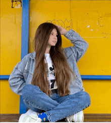 a girl with long hair is sitting on a bench with her legs crossed wearing a mickey mouse shirt with the number 7 on it