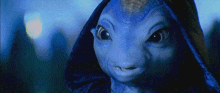 a close up of a blue alien with a hood