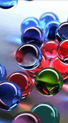 a bunch of colorful glass balls are floating on a table .