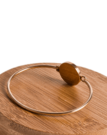 a gold bracelet is sitting on a wooden table