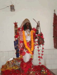 a statue of a woman holding a sword is surrounded by flowers .