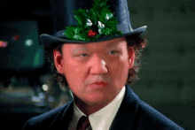 a man wearing a top hat with a holly on it