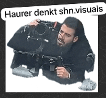 a man is taking a picture with a camera and the words hauer denkt shn.visuals are above him