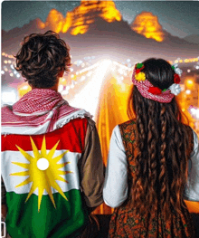 a man and a woman looking at a mountain with a flag on their back