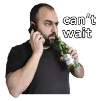 a man talking on a cell phone while holding a bottle of beer that says " can 't wait "