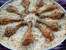 a plate of rice with chicken legs on top