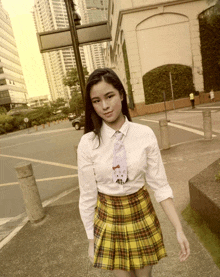 a girl wearing a hello kitty tie and a yellow plaid skirt