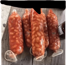 a bunch of sausages wrapped in beans and condoms on a table