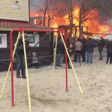 a group of people standing in front of a fire with a sign that says ' a ' on it