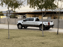 a white ford truck is parked in front of a brick wall