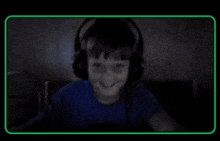 a boy wearing headphones and a blue shirt is smiling