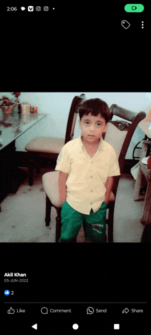 a little boy is sitting in a chair with his hands in his pockets and a facebook post says akil khan