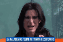 a woman is crying in front of a sign that says la palabra de felipe pettinato recuperado