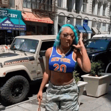 a woman with blue hair is wearing a new york jersey and smoking a cigarette in front of a jeep .