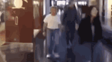 a blurry picture of people walking down a hallway .