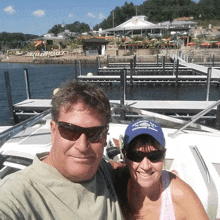 a man and a woman are posing for a picture in front of a boat