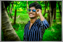 a young man wearing sunglasses and a striped shirt