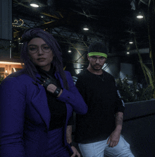 a woman in a purple suit stands next to a man with glasses