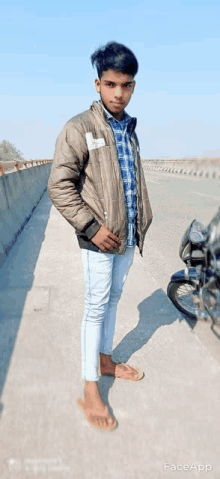 a young man is standing next to a motorcycle on a sidewalk