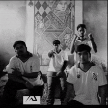 a group of young men are posing in front of a wall with a painting of a queen of spades on it