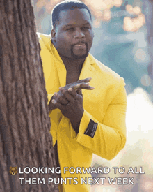 a man in a yellow suit is peeking out from behind a tree with the caption looking forward to all them punts next week