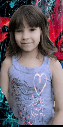 a little girl in a tank top that says love you