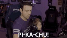 a man in a secret lab shirt holds a child in his arms and says pi-ka-chu