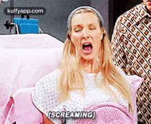 a woman in a hospital gown is screaming in a hospital bed .