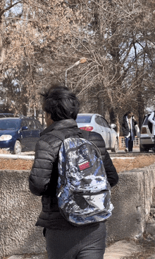 a man wearing a black jacket and a blue backpack