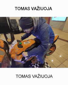 a man sits on a toy motorcycle with the name tomas written on the bottom