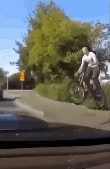 a person is riding a bike down a street in front of a yellow sign that says ' do not enter '