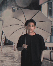 a man in a black shirt holds an umbrella