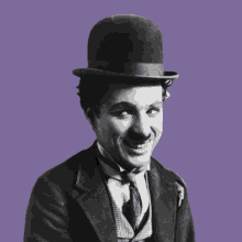 a black and white photo of a smiling man wearing a hat