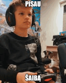 a young boy is wearing headphones and playing a video game .