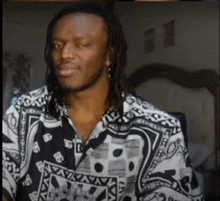 a man with dreadlocks wears a black and white shirt with the letters aa on it