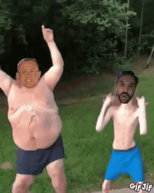 a fat man and a bearded man are dancing together in the grass ..