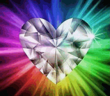 a diamond in the shape of a heart is surrounded by rainbow colored lights