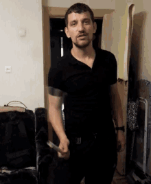 a man in a black shirt is holding a hammer