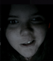 a close up of a woman 's face with a dark background