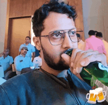 a man wearing glasses is drinking from a green bottle of beer