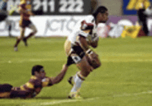 a rugby player with the number 8 on his jersey is being tackled