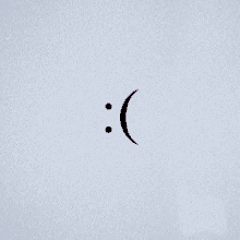 a purple smiley face with two dots on a white background .