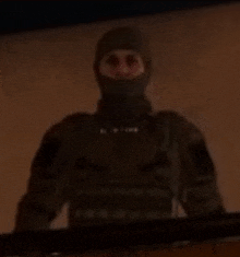 a soldier wearing a mask is standing in the dark .