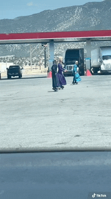 two people walking in a parking lot with mountains in the background and a tiktok watermark