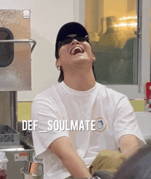 a man wearing sunglasses and a white shirt that says soulmate is laughing