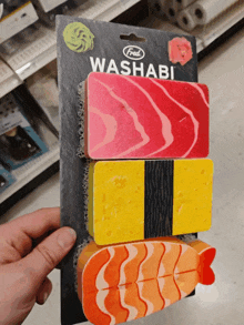 a person is holding a package of sushi shaped sponges that say fred washabi