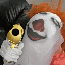 a person dressed as a clown is holding a gold gun