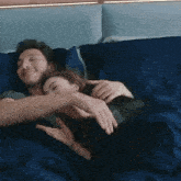 a man and a woman are hugging each other on a bed